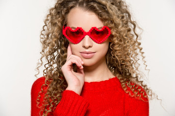 Valentine's Day. Beautiful girl in red sweater with  glasses hearts.

