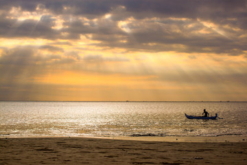 Fototapeta na wymiar Sunset with sea view and lonely boat in Bali, Indonesia