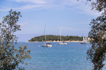 Obraz na płótnie Canvas Sail boats and clear blue water in a Croatian bay, golden cape