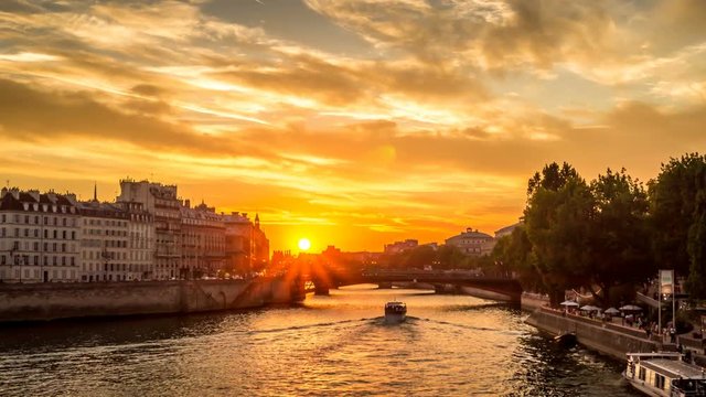 Timelapse of Ile de la Cit&eacute; in Paris and people walking on the docks, with boats passing by under the bridges, view from Louis-Philippe bridge