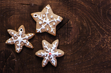 Homemade colorful gingerbread cookies on dark wooden background.