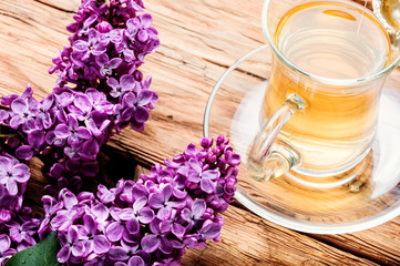 Fototapeta na wymiar Cup of tea and lilac flowers