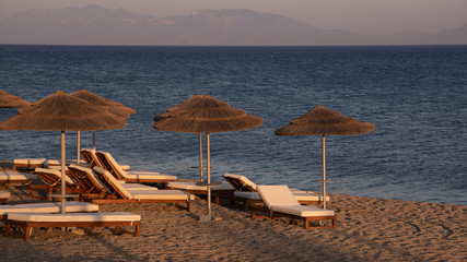 Parasols et bains de soleil sur la plage de Kos au crepuscule