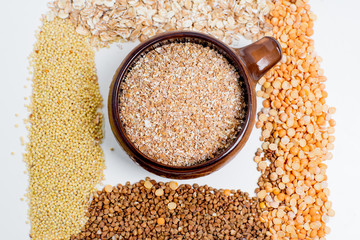 different types of groats in pots on a white background