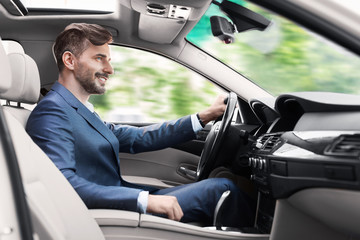 Elegant man in business suit driving car