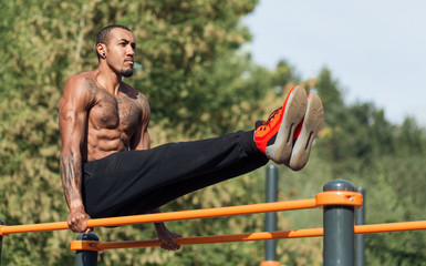 Strong athlete doing leg lifting abs exercise