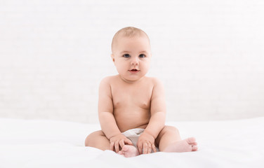 Cute baby sitting on white background, copy space