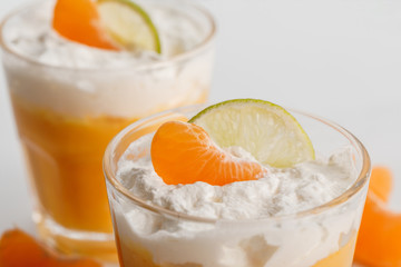 close up of two glasses of cream desserts with tangerine and lime slices