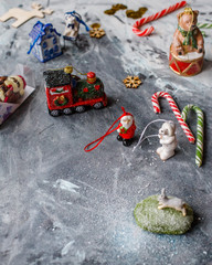 Fototapeta premium New Year's composition of vintage Christmas toys on a gray table with lollipop