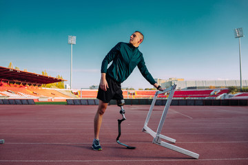 Athlete with prosthetic leg on running track