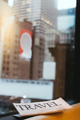 close up view of travel newspaper and new york city on background