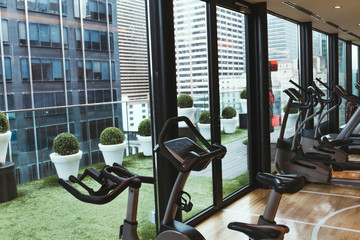close up view of exercise equipment in gym and flowerpots on balcony