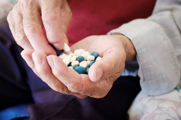 senior man with a pile of pills in his hand