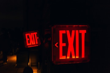 close up view of red exit sign on black backdrop