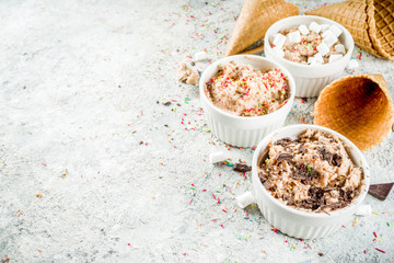 Edible Raw Cookie Dough, sweet modern dessert, with waffle ice cream cones on grey stone background, copy space