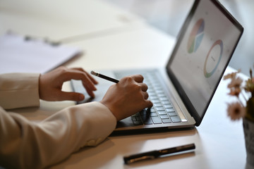 Fototapeta premium Cropped shot of business woman working on her laptop at desk