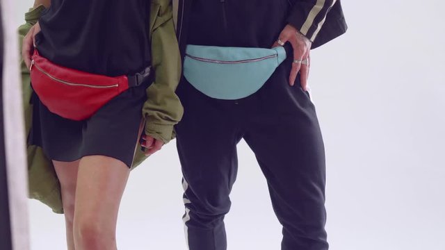 Legs of man and woman with fanny packs on hips