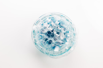 A circle of soap bubbles from blue shower gel on a white background.