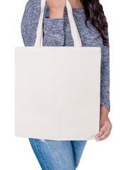 Woman in jeans holding blank textile bag isolated. Mockup for design