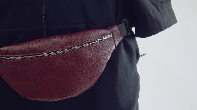 Brown fanny pack is on hips of model. Photo session of fashionable fanny pack.