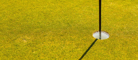 golf course putting green hole with flag pole