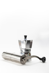Moka pot and coffee grinder on white background