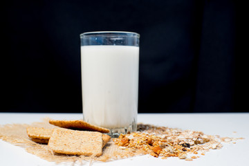 a glass of milk with bread and grains