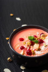 Healthy food by color of 2019 living coral Yogurt Breakfast Bowl  with coconut, almond, flax seeds, Granola, and red currants in ceramic bowl with copy space