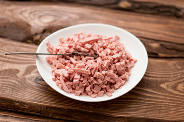 Obraz na płótnie Canvas Finely chopped boiled sausage on a white plate.