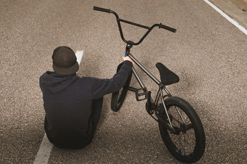 Guy standing bmx bike. BMX rider with and a sunset. Extreme urban sports