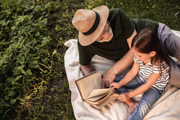 Girl with her grandfather relaxing on weekend in countryside