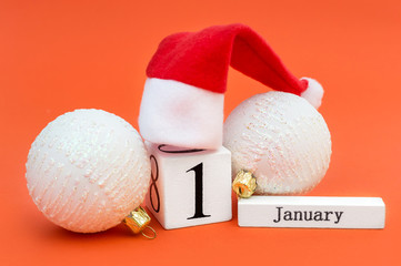 Date of 1st january on wooden cubes with santa hat and christmas balls. New year concept.