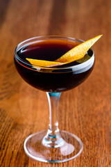 Black Manhattan Cocktail closeup on bar counter with copy space