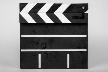 Clapper for indicating the beginning of a film or video clip made of wood and painted black and...