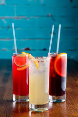 row of various colourfull alcoholic cocktails on a bar desk