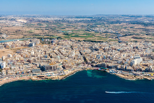 Aerial view of Bugibba town, St. Paul's Bay in the Northern Region, Malta. Popular tourist resort destination with promenade, hotels, restaurants, pubs, clubs, and a casino.