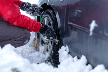 Clutching the snow chains. Snow chains on the wheels of car..