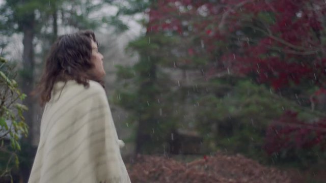 Very chilly woman tries to stay warm as snow flurries come down in early winter