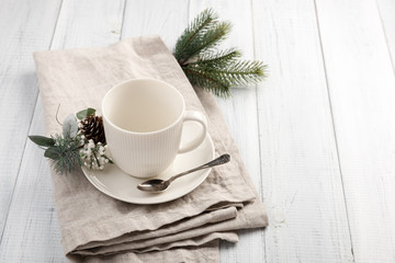 Empty cup under hot chocolate on the white wooden table. Winter cocoa drink on a napkin 