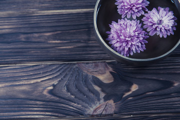 Singing bowl with candles with pebbles on dark wooden background