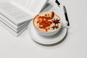 Open book with pen and coffee Cup on white table