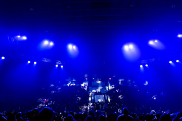 Fototapeta na wymiar Concert crowd in the rays of blue spotlights.
