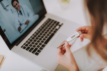 Pregnancy test in woman hands against laptop