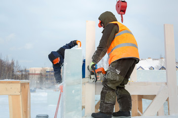 Portrait of a fitter in an orange vest with a chainsaw in his hands