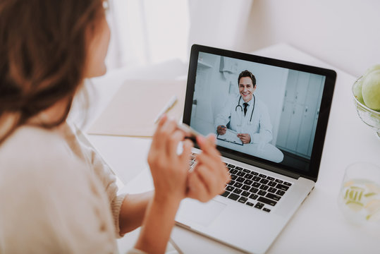 Cheerful doctor making video-call to his patient at home