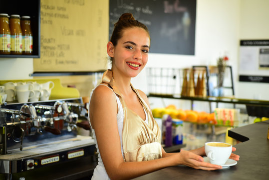 A Quick Cup To Start A Hectic Workday Morning. Pretty Woman Stand Behind Cafe Counter. Brewing Coffee In Coffeehouse. Barista Serve Cup Of Hot Coffee Drink With Smile. Woman Barista In Coffee Shop