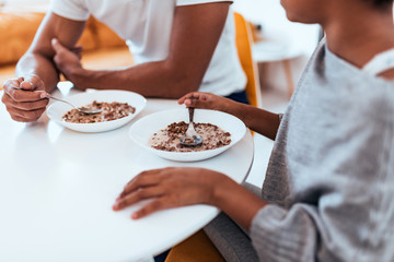 Obraz na płótnie Canvas African american family eating healthy breakfast. Close-up.