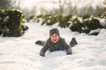 Fototapeta na wymiar A boy in winter clothes jumps into the snow. Happy holiday