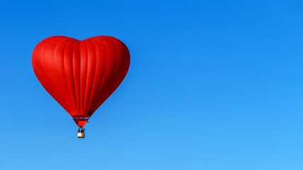 Fototapeta na wymiar red balloon in the shape of a heart against the blue sky