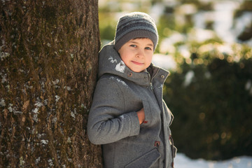 Boy walkink in the park at winter holiday. Christmas mood